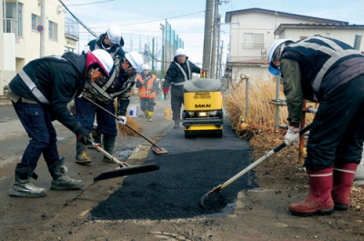 写真:歩道を補修する菱中建設室蘭支店の社員