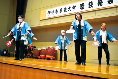 写真:うちわを両手に踊る法被姿のレクリエーション教室メンバー