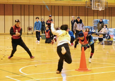 写真:飛んでくるボールをかいくぐりカラーコーンを奪いに走る選手