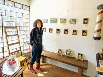 写真:ネコを描いた作品を紹介する坪川さん