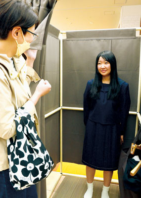 写真:サイズ感や着心地を確認しながら制服を試着する女子生徒=17日、洋服の青山MORUE中島店