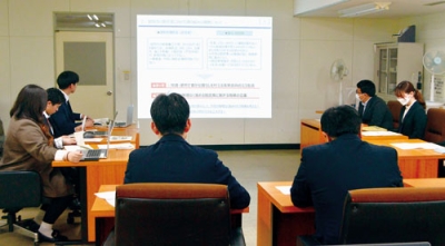 写真:小笠原市長らに脱炭素実現に向けた案を報告する若手職員ら