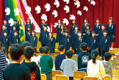 写真:卒業の歌「最後のチャイム」を合唱する卒業生=18日、地球岬小