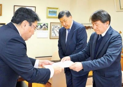 写真:小笠原市長(左)へ提言書を手渡す吉田委員長(右)と福井副委員長