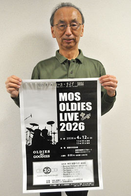 写真:ポスターを手に来場を呼びかけるMOSの柴原事務局長