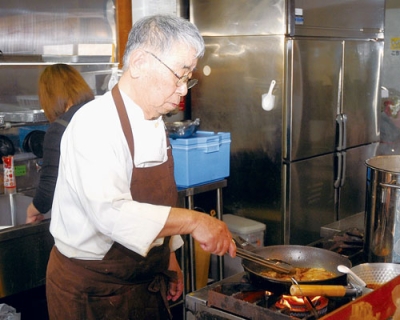 写真:厨房で腕を振るう蝦名さん