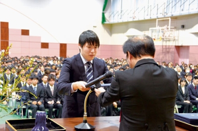 写真:松田学長から学位記を受け取る卒業生代表