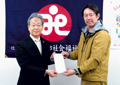 写真:善意を影山会長(左)に手渡す矢野社長